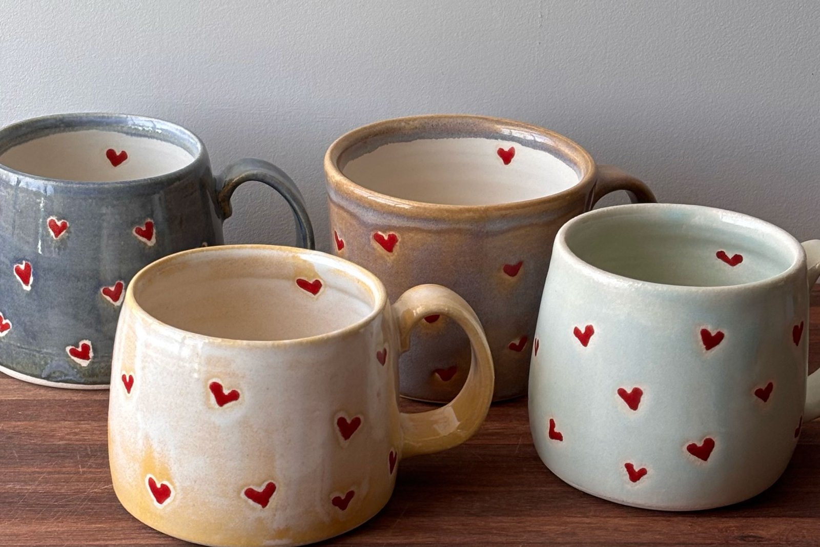 handmade pottery mug with small red hearts
