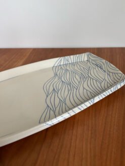 close up of pottery platter with wave pattern